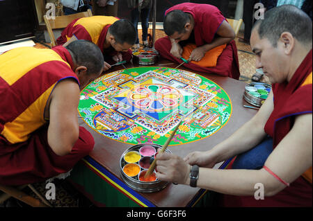 (Dans le sens des aiguilles d'une montre en haut à gauche) Kachen Choedrak, Ven Lobzang Thokmed, Kachen Namgyal et Kachen Lobzang Tuskhor, moines du monastère de Tashi Lhunpo, faisant un Mandala de sable de Chenrezig de compassion et de bonté dans le Chapitre House de la cathédrale de Salisbury. Banque D'Images