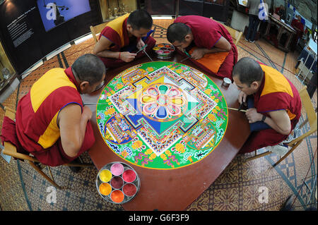 (Dans le sens des aiguilles d'une montre en haut à gauche) Kachen Choedrak, Ven Lobzang Thokmed, Kachen Namgyal et Kachen Lobzang Tuskhor, moines du monastère de Tashi Lhunpo, faisant un Mandala de sable de Chenrezig de compassion et de bonté dans le Chapitre House de la cathédrale de Salisbury. Banque D'Images