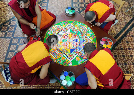 (Dans le sens des aiguilles d'une montre en bas à gauche) Kachen Choedrak, Ven Lobzang Thokmed, Kachen Namgyal et Kachen Lobzang Tuskhor, moines du monastère de Tashi Lhunpo, faisant un Mandala de sable de Chenrezig de compassion et de bonté dans le Chapitre House de la cathédrale de Salisbury. Banque D'Images