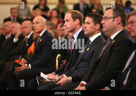 Le duc de Cambridge, en sa qualité de président de la FA, siège avec l'ancien footballeur d'Angleterre Michael Owen (deuxième à droite), lors d'une cérémonie dans la salle de bal de Buckingham Palace, avant la remise de médailles à 150 volontaires en reconnaissance de leur engagement dans les jeux locaux, Après un match de football entre le civil Service FC et le Polytechnic FC dans le jardin de Buckingham Palace, dans le centre de Londres. Banque D'Images