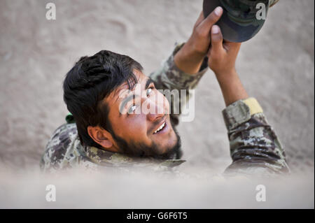 Un soldat de l'Armée nationale afghane (ANA) est assis à l'ombre lors d'une pause entre deux séances d'entraînement au camp de l'ANA Shorabak, dans la province de Helmand, en Afghanistan. Banque D'Images