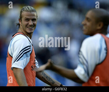 David Beckham du Real Madrid apprécie les blagues avec Roberto Carlos (à droite) lors de l'échauffement avant son premier match de la Ligue espagnole contre Real Betis, que le Real Madrid a remporté en 2.1, lors du match de la Ligue espagnole Primera au stade Bernabeu à Madrid, en Espagne. Banque D'Images