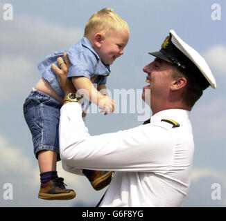 L'officier des systèmes tactiques, John Livesey, salue son fils de 16 mois Harry, alors que le HMS Splendid retourne du Golfe à la base navale de HM Clyde, Faslane. Les 107 membres de l'équipage ont été déployés dans la région du Golfe au début de janvier et ont tiré des missiles Tomahawk Cruise contre des cibles terrestres en Iraq pendant le conflit. Banque D'Images