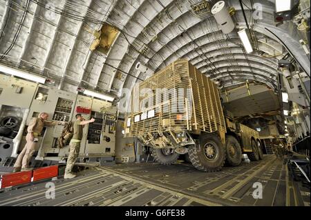 Un camion lourd de combat à huit roues, équipé d'une armure de barre, est renversé et chargé sur un C-17 sur la piste du Camp Bastion, province d'Helmand, Afghanistan, Où il reviendra au Royaume-Uni dans le cadre du redéploiement de l'équipement du théâtre au fur et à mesure que le retrait progresse, prêt pour le retrait total des forces britanniques en 2014. Banque D'Images