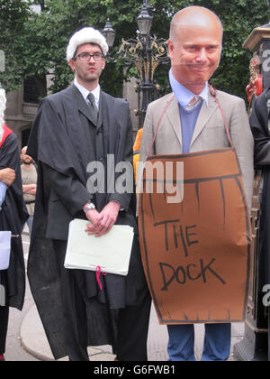 Les manifestants, dont un en costume comme secrétaire à la Justice Chris Grayling (à droite), ont organisé un barrage routier devant les cours royales de justice pour s'opposer aux changements proposés par le gouvernement à l'aide juridique. Banque D'Images