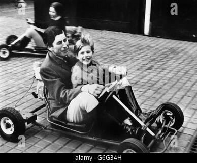 Le Prince Charles donne à son frère de cinq ans, Prince Edward, un tour de kart dans le parc du château de Windsor. La princesse Anne conduit son propre kart en arrière-plan. Banque D'Images