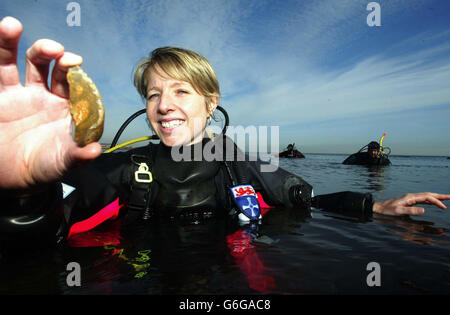 Penny Spikins, dans la mer du Nord à Tynemouth, avec une pierre trouvée par son équipe d'archéologues de plongée sous-marine lorsqu'ils ont découvert un règlement sous-marin qui pourrait être âgé de 10,000 ans. On croit que la colonie, qui se trouve à l'embouchure de la rivière Tyne, est le deuxième développement du pays à l'âge de pierre submergée. Banque D'Images