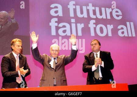 Le secrétaire d'État à la Santé, John Reid (au centre), est applaudi par le premier ministre Tony Blair (à gauche) et son adjoint John Prescott, après avoir prononcé son discours principal à la Conférence du Parti travailliste à Bournemouth. Banque D'Images