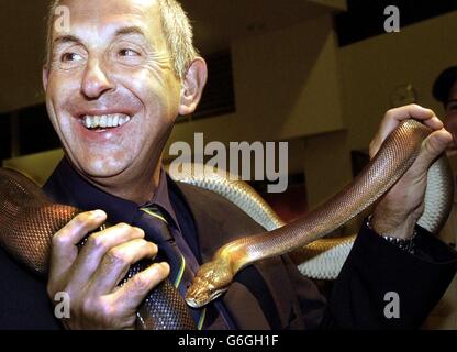 Ian McGeechan, entraîneur de l'équipe d'Écosse, avec un Olive Python australien au Townsville Tropical Museum, le vendredi 10 octobre 2003, où l'équipe est arrivée pour une réception avant leur match de la coupe du monde contre le Japon à Townsville le dimanche 12 octobre. Photo PA : David Cheskin. PAS D'UTILISATION DE TÉLÉPHONE MOBILE. LES SITES INTERNET NE PEUVENT UTILISER QU'UNE IMAGE TOUTES LES CINQ MINUTES PENDANT LE MATCH Banque D'Images