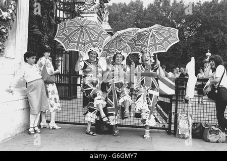 Trois « Royalistes » de Manchester, (l-r) Christine Heron, sa mère Ruth et Ethel Knape, portent des tenues de l'Union Jack devant Buckingham Palace à Londres pendant qu'ils regardaient les arrivées pour le baptême du prince William du pays de Galles. Banque D'Images