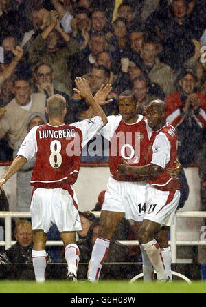 Thierry Henry (au centre) d'Arsenal célèbre sous la pluie avec ses coéquipiers Fredrik Ljungberg (à gauche) et Sylvain Wiltord après avoir marquant le but d'ouverture contre Newcastle United lors du match FA Barclaycard Premiership à Highbury, dans le nord de Londres. Banque D'Images