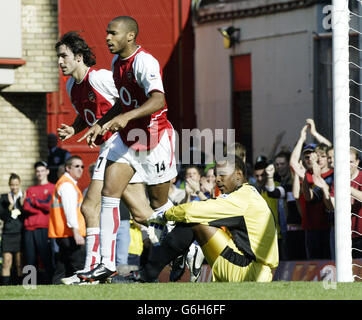 Thierry Henry, d'Arsenal, célèbre son objectif de pénalité avec Robert pires (à gauche), coéquipier de Portsmouth, Shaka Hislop (à droite), qui montre son éjection, lors de son match de First ership de FA Barclaycard au Highbury Ground d'Arsenal, dans le nord de Londres. Banque D'Images