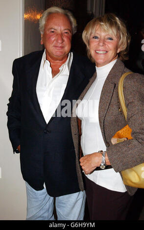 Le réalisateur Sir Michael Winner et sa petite amie Geraldine Lynton Edwards arrivent à la visite privée de la collection personnelle de Sir Elton John, à Sotheby's, dans le centre de Londres. La collection doit être mise aux enchères le 30 septembre 2003. Banque D'Images