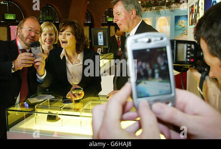 Cherie Blair, épouse du Premier ministre Tony Blair, se voit exposer un téléphone mobile de pointe lors de la tournée des stands de l’exposition à la Conférence du Parti travailliste de Bournemouth.M. Blair et ses collègues leaders travaillistes sont confrontés à des troubles syndicaux sur l'Irak, aux frais des universités et aux hôpitaux de fondation lors du rassemblement de Bournemouth, et le chancelier Gordon Brown a pris des risques de colère supplémentaires aujourd'hui en signalant la fin des négociations salariales nationales. Banque D'Images