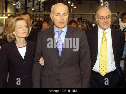 Le chef du Parti conservateur Iain Duncan Smith, son épouse Betsy et le chancelier de l'ombre Michael Howard, ont visité une usine de plastique à Blackpool, au cours de la conférence du parti cette semaine. Duncan Smith a aujourd'hui écarté les suggestions selon lesquelles les « combinaisons grises » du parti devaient faire passer le temps à sa direction. Parmi les affirmations selon lesquelles jusqu'à 15 députés conservateurs de l'arrière-ban réclamaient un vote de défiance envers sa direction, M. Duncan Smith insistait sur le fait que son objectif était de mettre fin au mandat de Tony Blair. Banque D'Images