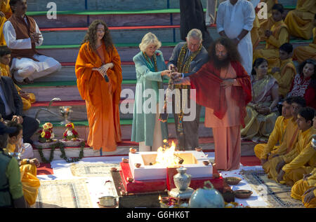 Le prince de Galles et la duchesse de Cornouailles versent de l'eau sur un feu avec le chef spirituel Pujya Swami Chidanand Saraswatiji (à gauche) et Saddvi Bhagawati Saraswati (à droite) lors de leur visite à la ville sainte hindoue de Rishikesh, pour assister à l'Aarti au coucher du soleil sur les rives du Gange, Dans le nord de l'Inde, le premier de la visite de onze jours de l'Inde et du Sri Lanka. Banque D'Images