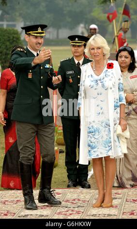 La Duchesse de Cornwall porte un coquelicot tricoté à la main alors qu'elle regarde un spectacle de cavalerie de l'armée, à l'Académie militaire indienne de Dehradun, dans le nord de l'Inde, le deuxième jour de leur tournée de onze jours en Inde et au Sri Lanka. Banque D'Images