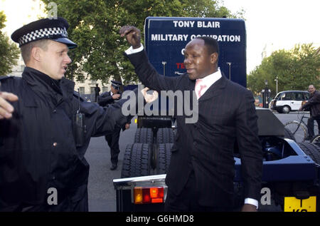 Chris Eubank, emmené par la police à l'extérieur de Downing Street, dans le centre de Londres, après avoir pris part à une manifestation d'un seul homme contre l'occupation militaire de l'Irak. Le showman flamboyant a soutenu son énorme camion devant Downing Street et a sonné son klaxon pendant environ une minute. Il a ensuite roulé avant de revenir pour une deuxième fois mais a été rapidement emmené après avoir fait marche arrière dans une camionnette et avoir sonné de nouveau son klaxon. Banque D'Images