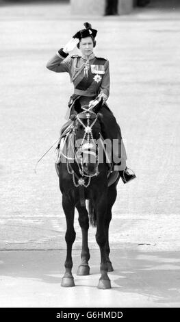 La Reine saluait alors que les gardes écossais défilaient devant le palais de Buckingham après la cérémonie de Trooping de la couleur sur la parade des gardes à cheval marquant son anniversaire officiel.Montée sur le birman, la jument noire qui lui a été présentée par la Gendarmerie royale du Canada, la Reine porte la tunique écarlate des gardes écossais avec port bleu foncé et chapeau tricorne noir.La couleur des gardes écossais du 2e Bataillon a été trooped. Banque D'Images