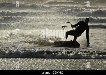 Un surfeur de cerf-volant peut faire le maximum des vents forts et du temps de tempête spectaculaire à Rest Bay, Porthcawl, pays de Galles. Banque D'Images