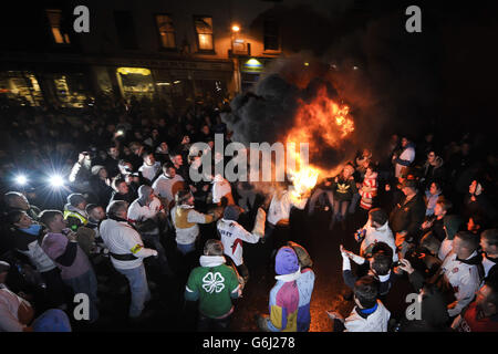 Les adultes du village Devonshire d'Ottery St Mary portent le Tar Barrel traditionnel à travers les rues du village la nuit de Bonfire. Banque D'Images