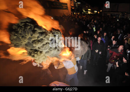 Les adultes du village Devonshire d'Ottery St Mary portent le Tar Barrel traditionnel à travers les rues du village la nuit de Bonfire. Banque D'Images