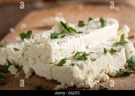 Tranches de fromage frais sur un fond de bois de persil Banque D'Images