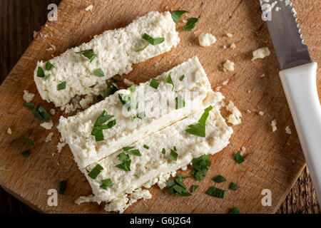 Tranches de fromage frais sur un fond de bois de persil Banque D'Images