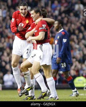 John O'Shea (à gauche) de Manchester United est passé pour féliciter le coéquipier Roy Keane (au centre) pour avoir obtenu le troisième but contre Portsmouth lors du match Barclaycard Premiership à Old Trafford, Manchester, Banque D'Images