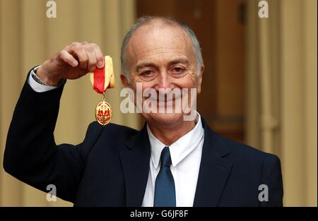 Sir Tony Robinson tient sa médaille après avoir été fait chevalier par le duc de Cambridge lors d'une cérémonie d'investiture à Buckingham Palace, dans le centre de Londres. Banque D'Images