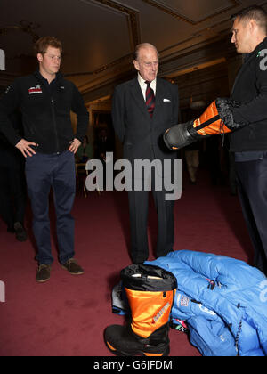 Le duc d'Édimbourg (au centre) et le prince Harry (à gauche) regardent une chaussure qui leur est présentée par un membre de Team USA, lors d'une réception pour rencontrer les trois équipes de militaires blessés du Royaume-Uni, des États-Unis et du Commonwealth, En avance sur la marche avec les blessés du South Pole Allied Challenge, à Buckingham Palace dans le centre de Londres. Banque D'Images