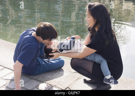 Les parents et little boy playing on riverbank Banque D'Images