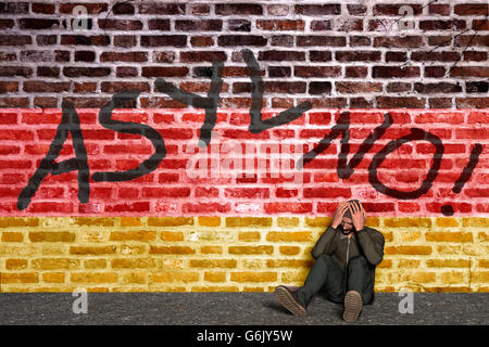Demandeur d'asile assis devant un mur avec écrit l'asile et de drapeau allemand, la tête dans ses mains, Computer Graphic Banque D'Images