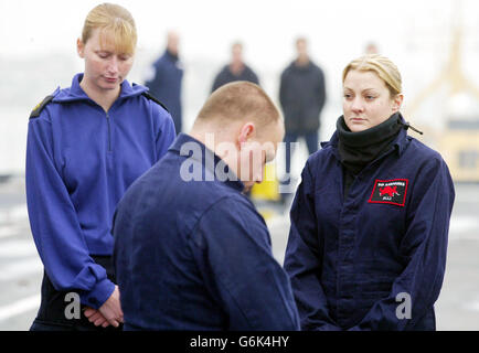 Les membres de l'équipage arrêtent le travail pour observer deux minutes de silence à 11:00 à bord du porte-avions HMS Ark Royal à Portsmouth en l'honneur des morts de guerre du Royaume-Uni. Banque D'Images