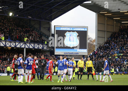 Football - Barclays Premier League - Everton / Liverpool - Goodison Park.Le tableau de bord électronique affiche le score final à la fin du jeu lorsque les joueurs se secouent la main sur le terrain Banque D'Images