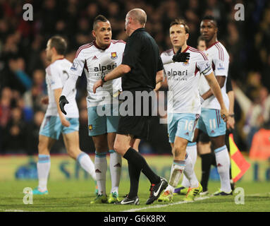 L'arbitre Lee Mason livre le Ravel Morrison (à gauche) de West Ham United sous la surveillance de Mark Noble, Après s'être impliqué avec Dean Moxey de Crystal Palace et James Tomkins de West Ham United se sont disputer lors du coup de sifflet final après la victoire de Crystal Palace en 1.0 dans le match de la Barclays Premier League à Selhurst Park, Londres. Banque D'Images