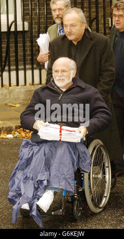 L'auteur Ron Kovic, qui a été paralisé pendant la guerre du Vietnam et a écrit le livre anti-guerre 'Born on the 4 of July' qui a été plus tard fait dans un film hollywoodien mettant en vedette Tom Cruise, est poussé dans Downing Street par George Galloway MP. Les deux faisaient partie d'un groupe qui a remis une pétition signée en 100,000, contre la visite du président George Bush des États-Unis d'Amérique en Grande-Bretagne plus tard cette semaine. Banque D'Images