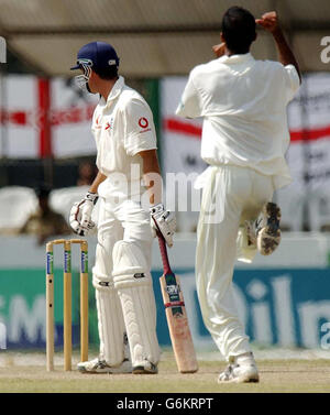 Le capitaine d'Angleterre Michael Vaughan quitte le terrain après avoir perdu sa cricket pour huit courses à Dinusha Fernando au Sri Lanka, alors qu'un très heureux Muttiah Muralitharan célèbre (au centre) le dernier jour du premier match d'essai, au stade international de Galle. L'Angleterre poursuit un total de 323 pour gagner le match. Banque D'Images