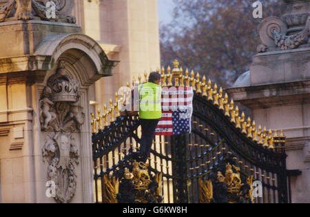 Un manifestant se tient aux portes de Buckingham Palace à Londres après avoir défait une bannière et ce qui semblait être un drapeau américain portant un slogan. Les passants et les médias ont été déplacés à au moins 100 mètres de la porte principale lors de la manifestation par la femme qui serait dans ses 50 ans, et qui est arrivée à la veille de l'arrivée du président américain George Bush pour sa visite d'État au Royaume-Uni. Le président Bush et sa femme seront invités de la Reine dans le Palais. Banque D'Images