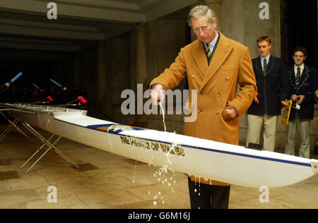 Le Prince de Galles verse du champagne sur le nouveau bateau du Trinity College -qui a été nommé d'après lui - au Trinity College de Cambridge, lors de sa visite sur son ancien site universitaire. Plus tôt, Charles a fait une visite au pub ykes End à la portée où il a joué aux fléchettes. Banque D'Images