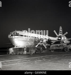 Années 1950, historique, vue de 'Castor' un Boeing 377 stratocruiser de la BOAC en cours d'entretien des avions sur une piste de nuit, un avion de la British Overseas Airways Corporation. Banque D'Images