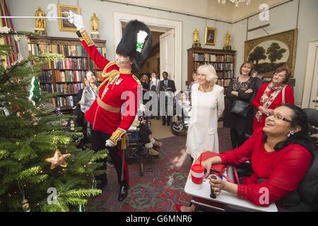 Le lieutenant Frederick Lloyd George, aide à décorer un arbre de Noël à Clarence House à Londres, lors d'une réception organisée par la duchesse de Cornwall, pour les jeunes et leurs soignants de Helen et Douglas House. Banque D'Images