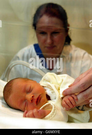 Ward soeur Mary Carlin avec un bébé qui a été découvert par un adolescent à l'extérieur de Mario's fast-food point dans la région de Cardonald de Glasgow, à l'hôpital général du Sud, Glasgow. La police croit que la mère peut avoir besoin d'une assistance médicale urgente et a fait appel à elle pour qu'elle se présente. Banque D'Images