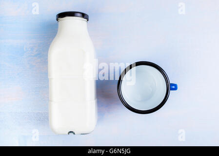 Bouteille de lait et tasse en métal sur la table de bois rustique, vue supérieure mise à plat Banque D'Images