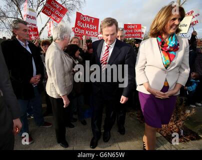 Taoiseach, Enda Kenny et la ministre de la protection sociale, Joan Burton TD, parlent aux parents d'enfants fréquentant l'école primaire de la salle à Ballyfermot qui risque d'être fermée, car ils arrivent pour le lancement de l'avantage de Work Ready Reckoner dans le nouveau centre Ballyfermot Intreo à Dublin. Banque D'Images