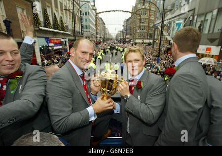 Le joueur d'Angleterre Lawrence Dallaglio et Josh Lewsey lors du défilé de victoire de l'équipe de rugby d'Angleterre, dans le centre de Londres. Les deux bus à toit ouvert sont arrivés à l'extérieur de la National Gallery pour accueillir des milliers de fans. La place était une mer de drapeaux rouges et blancs tandis que les héros du pays se sont emparés de fans. Banque D'Images