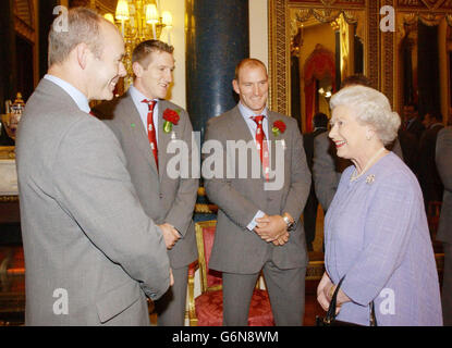 La reine Elizabeth II de Grande-Bretagne rencontre l'entraîneur de rugby d'Angleterre Clive Woodward (L), et les joueurs vont Greenwood (au centre) et Lawrence Dallaggio à Buckingham Palace, Londres.Plus tôt, l'équipe avait défilé le trophée William Ellis à travers le West End dans une procession de bus à toit ouvert. Banque D'Images