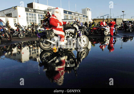 Un motard vêtu d'une tenue du Père Noël se joint à plus d'une centaine de motocyclistes au Ace Cafe, Brant, dans le nord de Londres, pour livrer des cadeaux de Noël aux enfants de l'hôpital Central Middlesex, de l'hôpital St Mary et de l'hôpital St Thomas. Banque D'Images