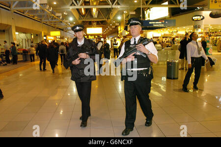 Des policiers armés patrouillent dans le terminal 4 de l'aéroport Heathrow de Londres, où le vol BA223 de British Airways à destination de Washington a été annulé pour des raisons de sécurité pour la deuxième journée consécutive. À la Saint-Sylvestre, le même vol a été gardé sur la piste pendant trois heures après l'atterrissage à l'aéroport international de Washington-Dulles afin de permettre aux agents de sécurité de monter à bord de l'avion et de poser des questions aux passagers. Banque D'Images