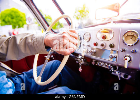 Close up méconnaissable homme conduisant une voiture vétéran Banque D'Images